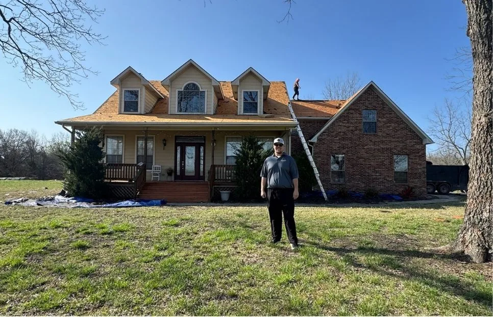 Shoemaker Snoddy project manager on site in front of a home mid-replacement