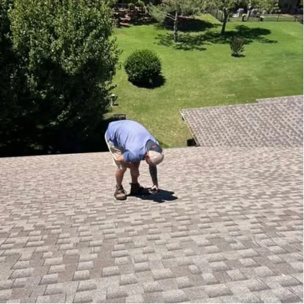 Shoemaker Snoddy crew member inspecting an asphalt shingle roof